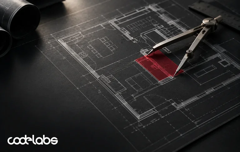 Steel drafting dividers measuring a building plan drawn in white on dark paper, with one section marked in red